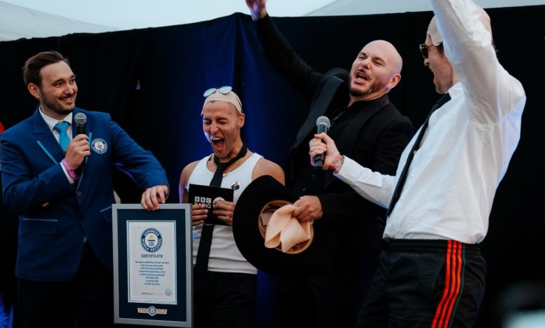 Pitbull merayakan Rekor Dunia Guinness bersama panitia setelah 22.141 penggemar mengenakan bald cap di konser BST Hyde Park London.
