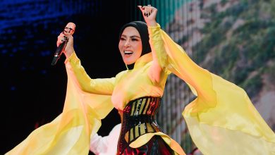 Syahrini tampil di panggung mengenakan busana kuning saat bernyanyi.
