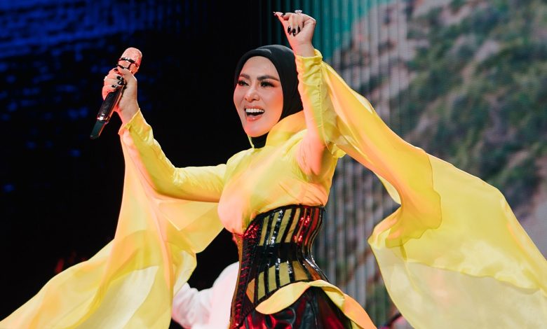 Syahrini tampil di panggung mengenakan busana kuning saat bernyanyi.